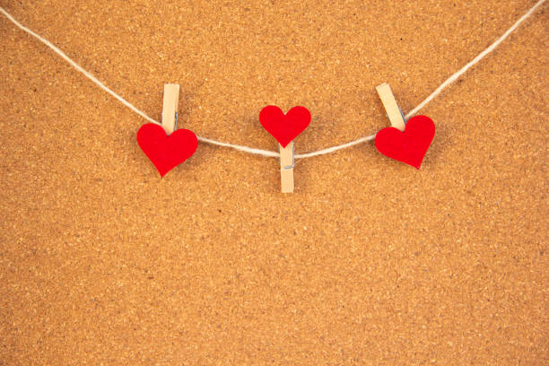 3 heart-shaped pegs on cork board