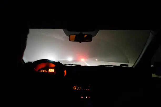 Photo of Foggy road. View from driving car at night.