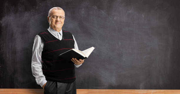 istock Elderly male teacher holding a book 1197296676