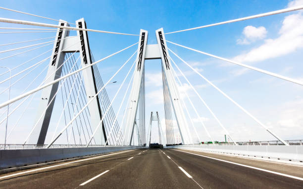 istock Sunspension bridge with empy road on the blue sky. Vibrant color. 1197296775