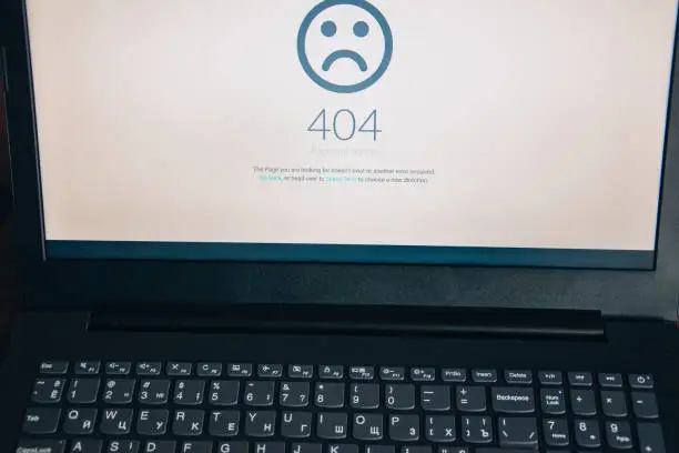 Computer 404 error failure concept, failure message on screen, bad software pc app crash, email malware, data loss and recovery, rear view over the shoulder Business laptop or office notebook computer PC