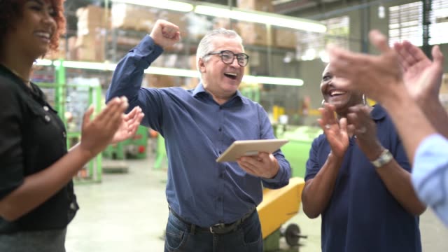 Coworkers celebrating some good news in a factory