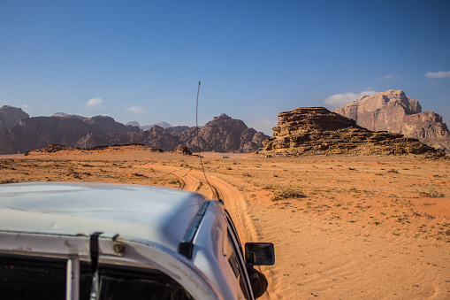 car sightseeing tour in wilderness desert dunes and dry rocks environment