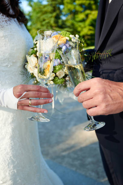 istock clink glasses by bride and groom 1197306474