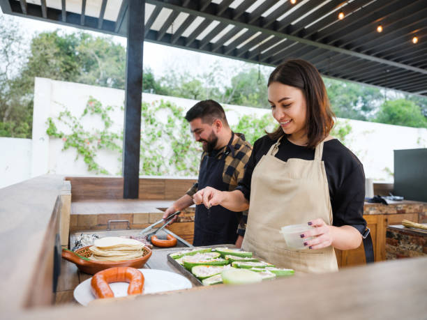 Happy couple grilling in terrace kitchen