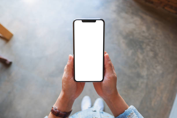 istock a woman holding black mobile phone with blank white screen 1197312187