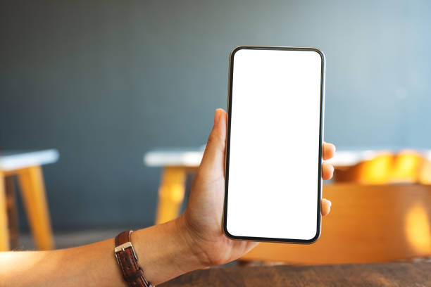 istock a hand holding and showing black mobile phone with blank screen in cafe 1197313562