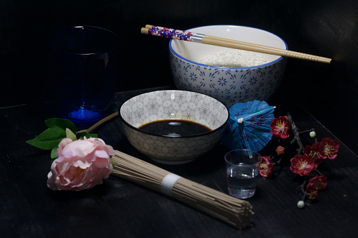 An oriental themed still life about food on a black background