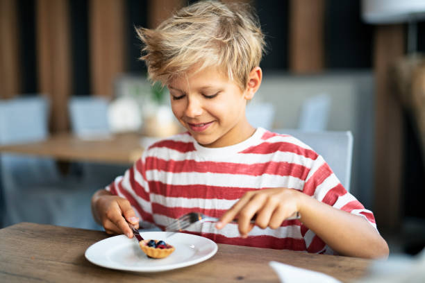 istock Little boy eating tiny cupcake with fruits 1197321743