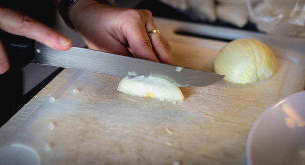 istock woman cuts onions on a white plastic board 1197322980