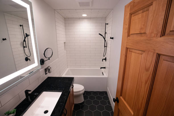 深いバスタブと黒の六角形の床タイルとマットブラックの備品を備えたモダンなバスルーム - master bathroom ストックフォトと画像