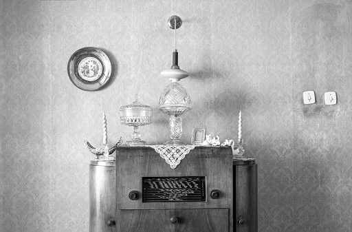 Vintage old radio on sixties, seventies wallpaper and furniture, antique, black and white