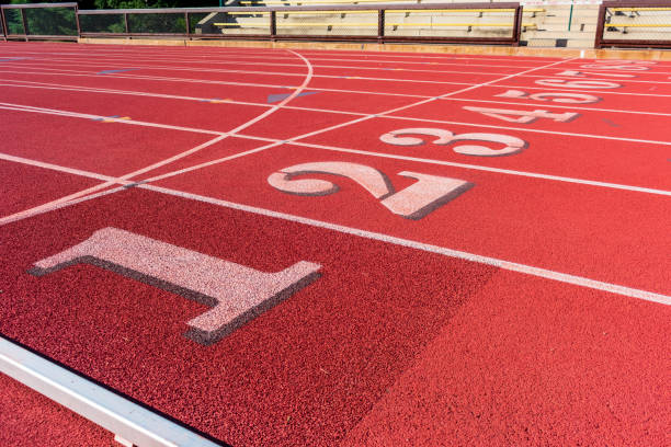 track and field race course lane numbers 1 thru 9. empty seats behind fence - starting line sprinting track and field track event imagens e fotografias de stock