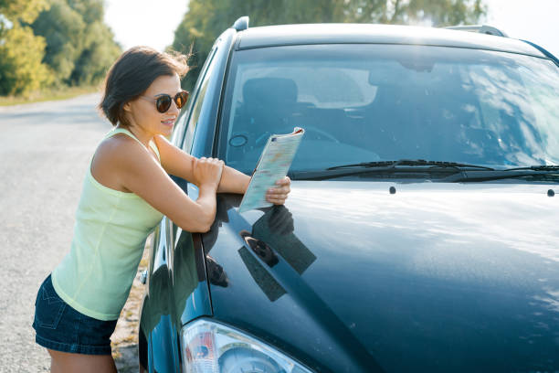 istock A female driver reading a map near a car 1197332508