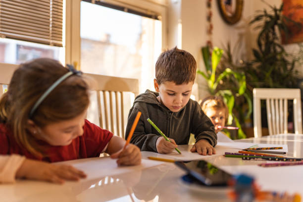 istock Kids drawing at table with colorful pencils 1197333724