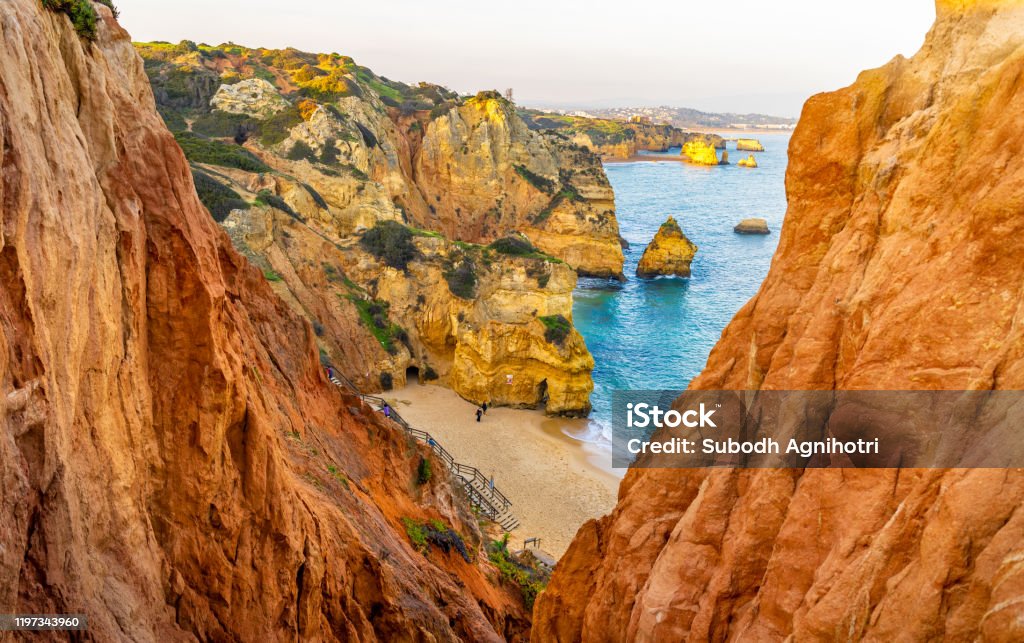 Beautiful Camilo Beach in Lagos, Portugal, with its rock cliffs and blue ocean. This pic shows wooden pathway at the beautiful Camilo Beach in Lagos, Portugal, with its magnificent cliffs and the blue ocean. The pic is taken in January 2020 in lagos Portugal. Portugal Stock Photo