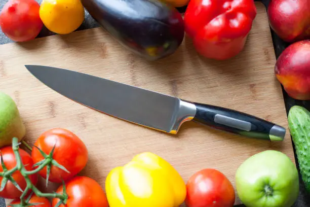 Still life of vegetables and kitchen-knife on cutting board