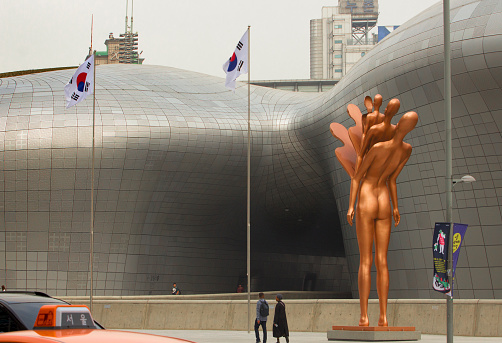 Dongdaemun, Seoul, South Korea April 1st, 2018: Statue and South Korean Flags in front of the Dongdaemun Design Plaza of Seoul, South Korea.