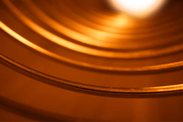 istock Orange metallic curved rings with light leak background 1197350591