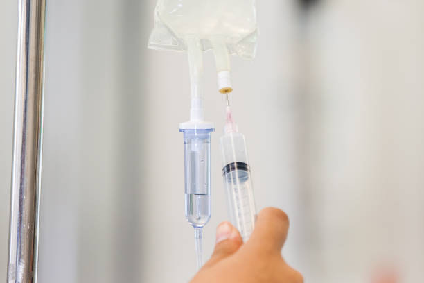 istock Nurse injecting a drug through an infusion system 1197351863