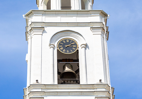 Russian orthodox church. Fragment of bell tower of the Iversky monastery with bell and chime clock in Samara, Russia