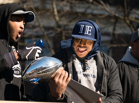Seattle, USA - February 5th, 2014: Bobby Wagner early in the day holding the Lombardi Trophy with Kenneth Bernard Wright during the Seahawks homecoming parade on 4th avenue after the XLVIII Super Bowl win.