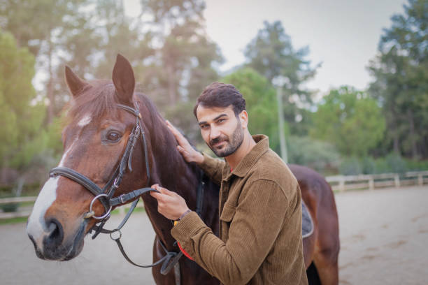 istock a young man walking with a brown horse 1197358257