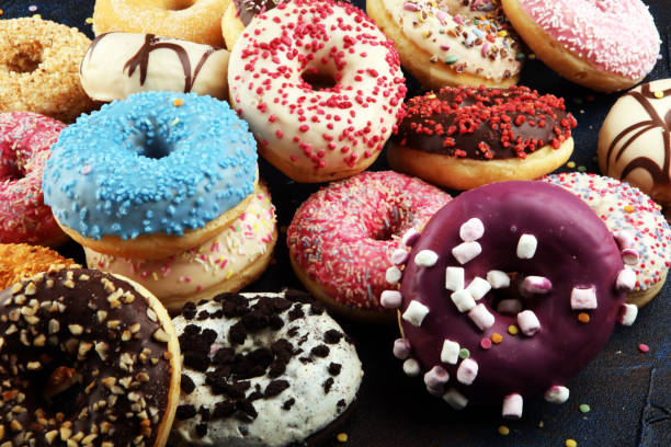 istock assorted donuts with chocolate frosted, pink glazed and sprinkles donuts 1197364580