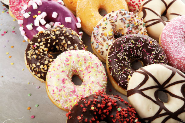 istock assorted donuts with chocolate frosted, pink glazed and sprinkles donuts 1197364768
