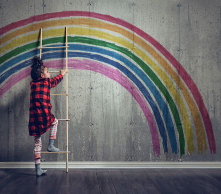 Girl climbing to reach the rainbow