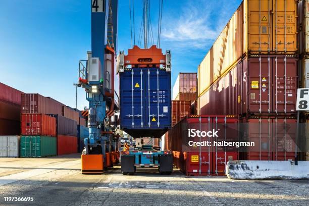 Rear View Of Straddle Carrier Lifting Container From Truck Stock Photo - Download Image Now