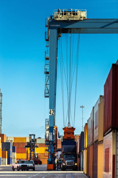 istock Straddle Carrier Lifting Container from Truck to Freight Train 1197366701