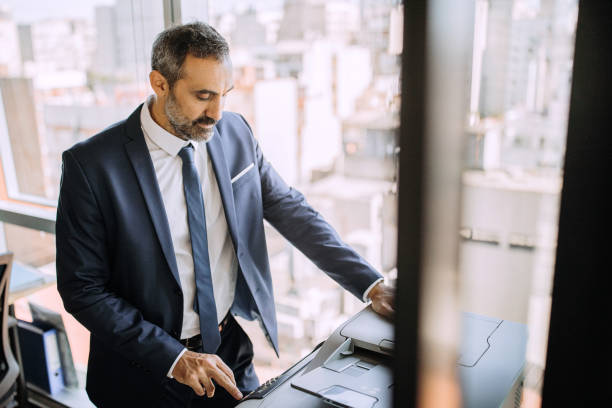 istock Businessman using photocopy machine at work place 1197368672