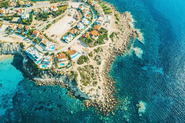 Aerial view of Cyprus island coast with villas for rent and rest and blue mediterranean sea, drone photo.