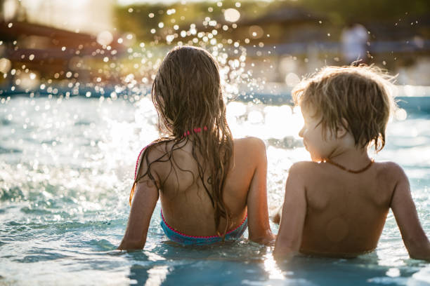 istock Rear view kids splashing in the pool 1197375055