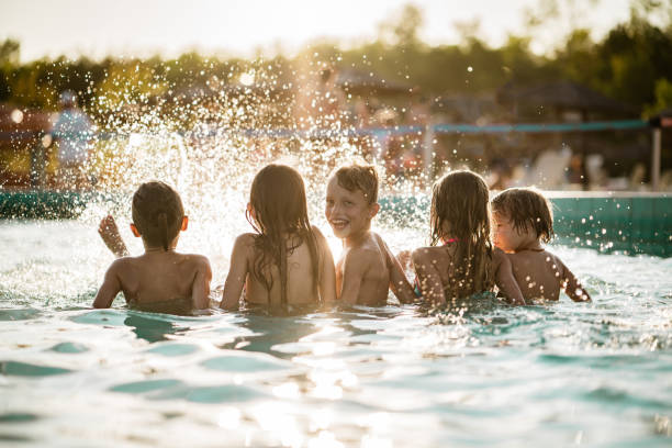 istock Rear view kids splashing in the pool 1197375123