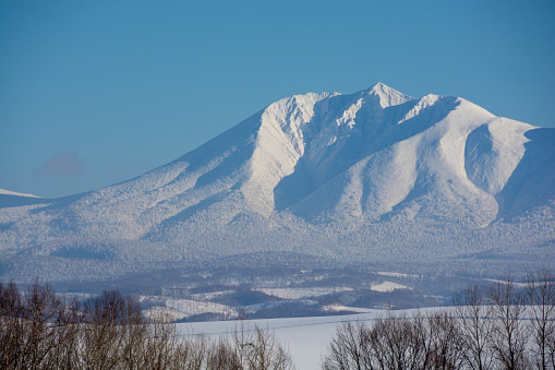 Blue sky and snowy mountain peak.Tokachidake mountain range