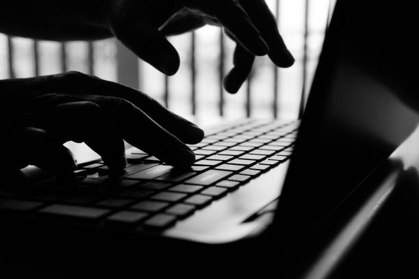 istock hacker or cyber crime hand reaching, stealing information on laptop, attack signifying internet theft while using online banking, anonymous business in technology internet and networking concept 1197393199