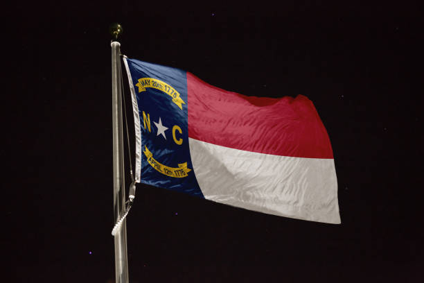 istock North Carolina flag blowing in the wind at night 1197394439