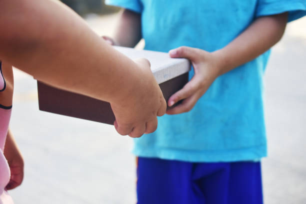 caja de regalo que da a mano, niños desfavorecidos en el sudeste asiático - underprivileged fotografías e imágenes de stock