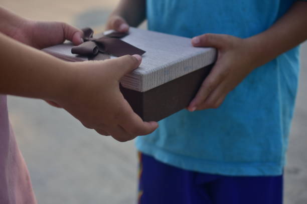 caja de regalo que da a mano, niños desfavorecidos en el sudeste asiático - underprivileged fotografías e imágenes de stock