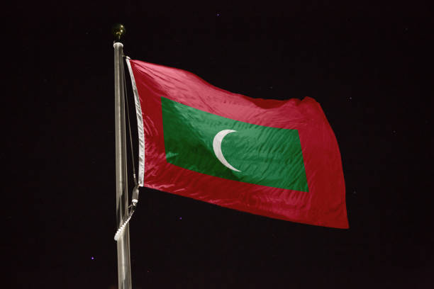 夜に風に吹くモルディブの旗 - maldivian flag ストックフォトと画像