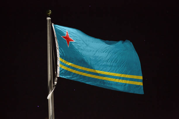 istock Aruba flag blowing in the wind at night 1197397966