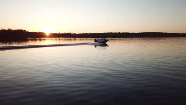 motor boat floating on the river at sunset