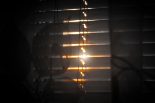 Sunlight breaks through thick
dark room curtains.