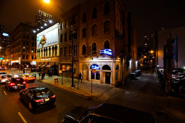 Chicago IL USA - Dec 29, 2019 : Take this picture of street view of Chicago downtown district street view. In the picture it was night time with heavy traffic and people walking on the wet pavement. There are cars waiting on the traffic signal and skyscraper in the background. On right is the famous landmark of Chicago and downtown eat outs.