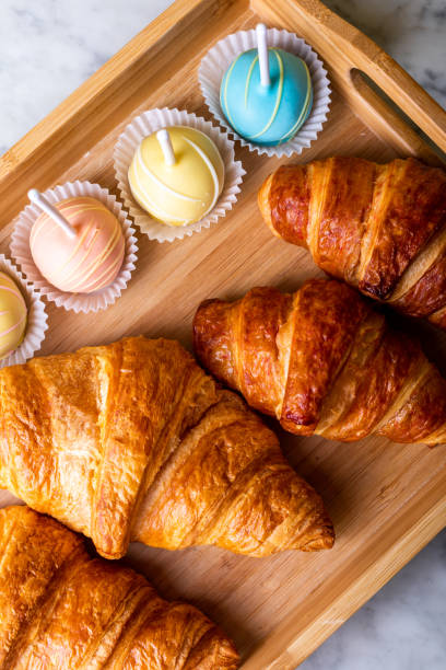 istock Cake pops and croissants on a wooden tray 1197418549