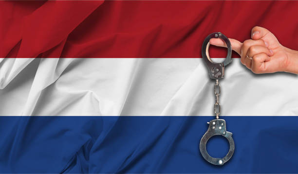 istock Netherlands  Flag with Male Hand Holding Handcuffs 1197420210