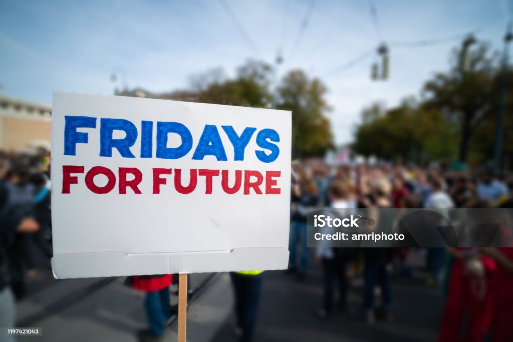 demonstrating to safe our planet fridays for future sign at protest march against climate change demonstration with many blurred people in the background Fridays for Future Stock Photo