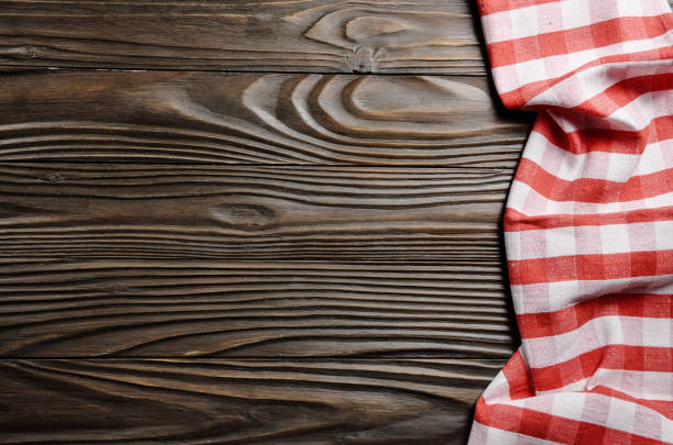 istock Red checkered napkin on brown wooden kitchen table with copy-space. Top view 1197424288
